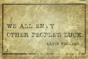 We all envy other people's luck - ancient Latin proverb printed on grunge vintage cardboard
