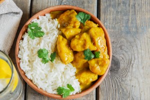 chicken curry with rice on a wooden surface