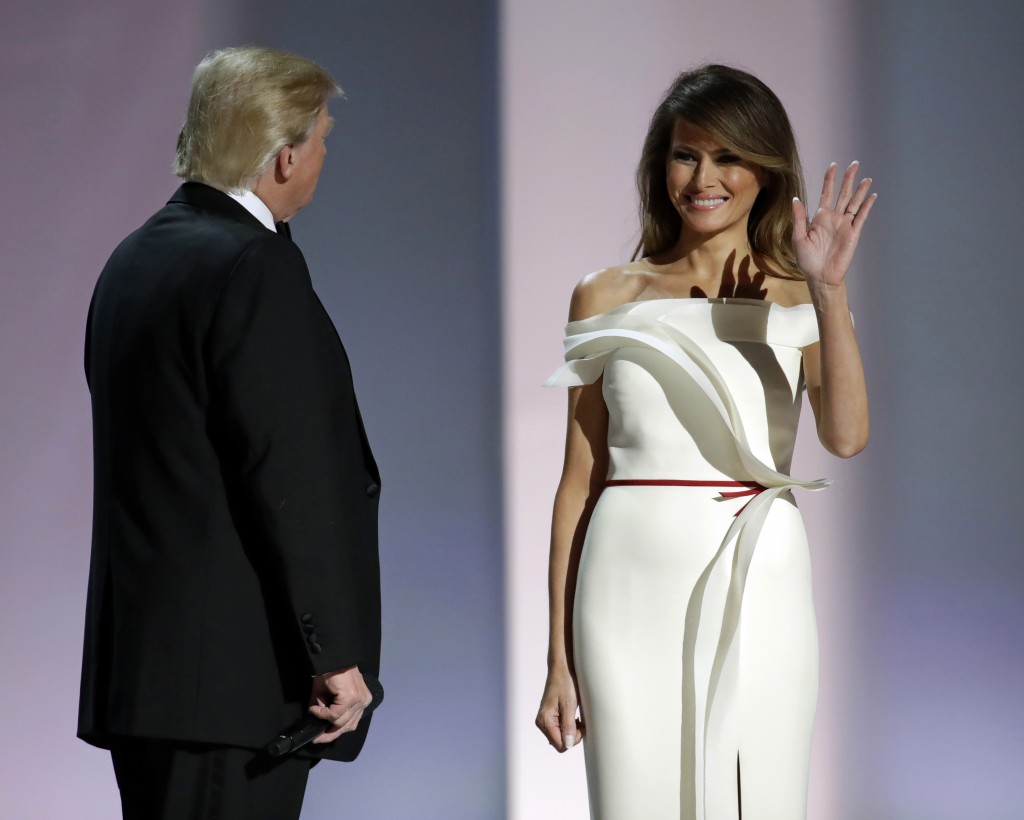 First lady Melania Trump, right, acknowledges supporters alongside President Donald Trump before dancing at the Liberty Ball, Friday, Jan. 20, 2017, in Washington. (AP Photo/Patrick Semansky)