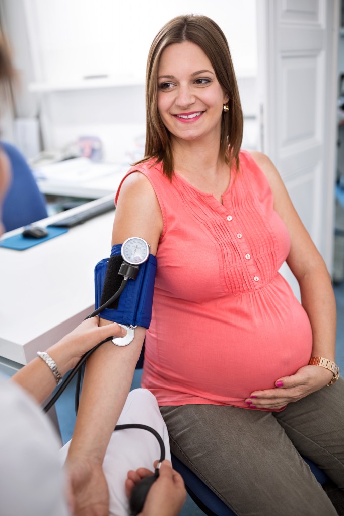 Nurse checking blood pressure of a pregnant woman in ambulances