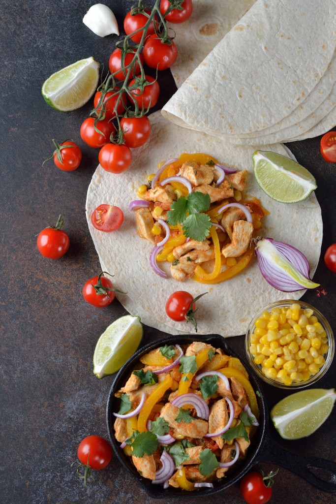 Fajita with chicken and yellow pepper on a brown background