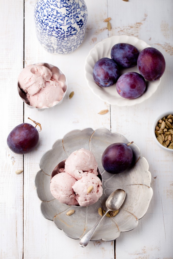 Plum ice cream with cardamon seeds on a white background