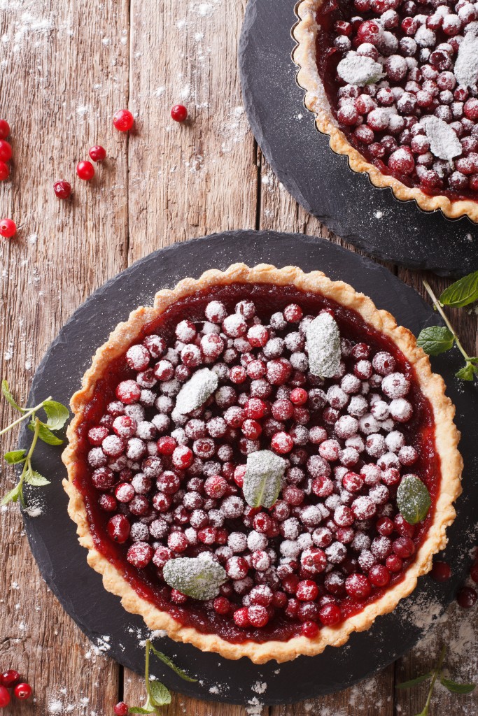 cranberry tart with jam, powdered sugar and mint close-up. Vertical top view