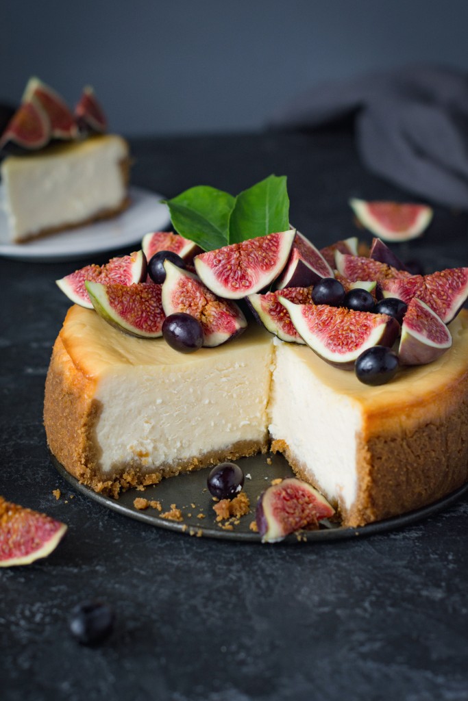 Delicious New York cheesecake with fresh figs and black grapes. Close up view.