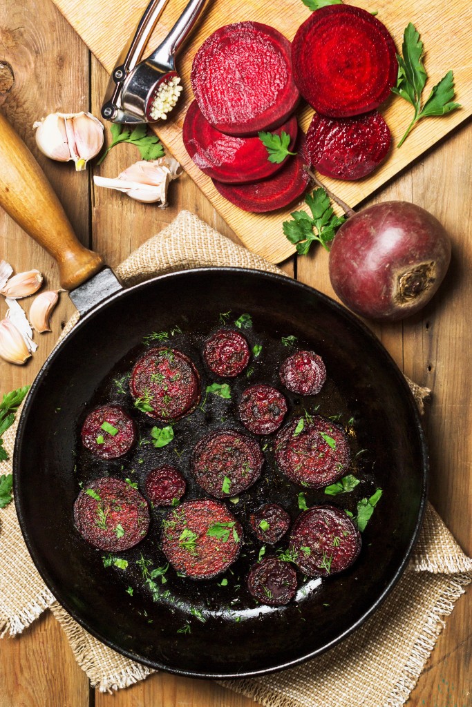 Fried beet slices on a cast-iron frying pan. Top view. Flat lay
